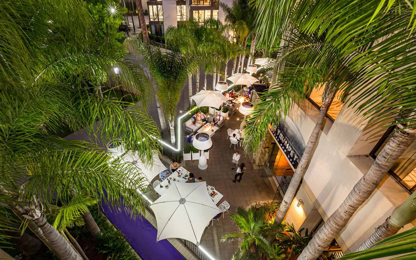 outdoor dining patio at Silver Trumpet Restaurant under umbrellas and trees